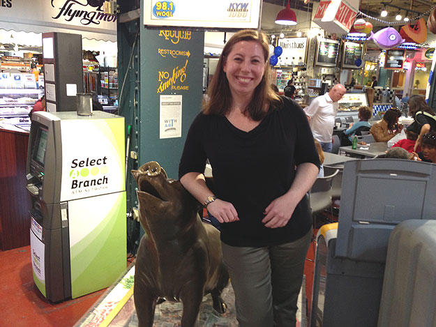 (Sarah Levitsky leans on the bronze sculpture of Philbert the Pig, the Reading Terminal Market mascot. Photo by Hadas Kuznits)