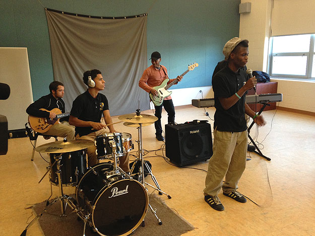 (Singer Jeffrey Williams, front, is accompanied by fellow students and visiting teacher Kevin Eubanks, in orange shirt.  Credit: Cherri Gregg)
