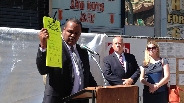 (L&I commissioner Carlton Williams shows an example of the type of new sign required for smaller construction sites in Philadelphia.  Photo by Mike Dunn)
