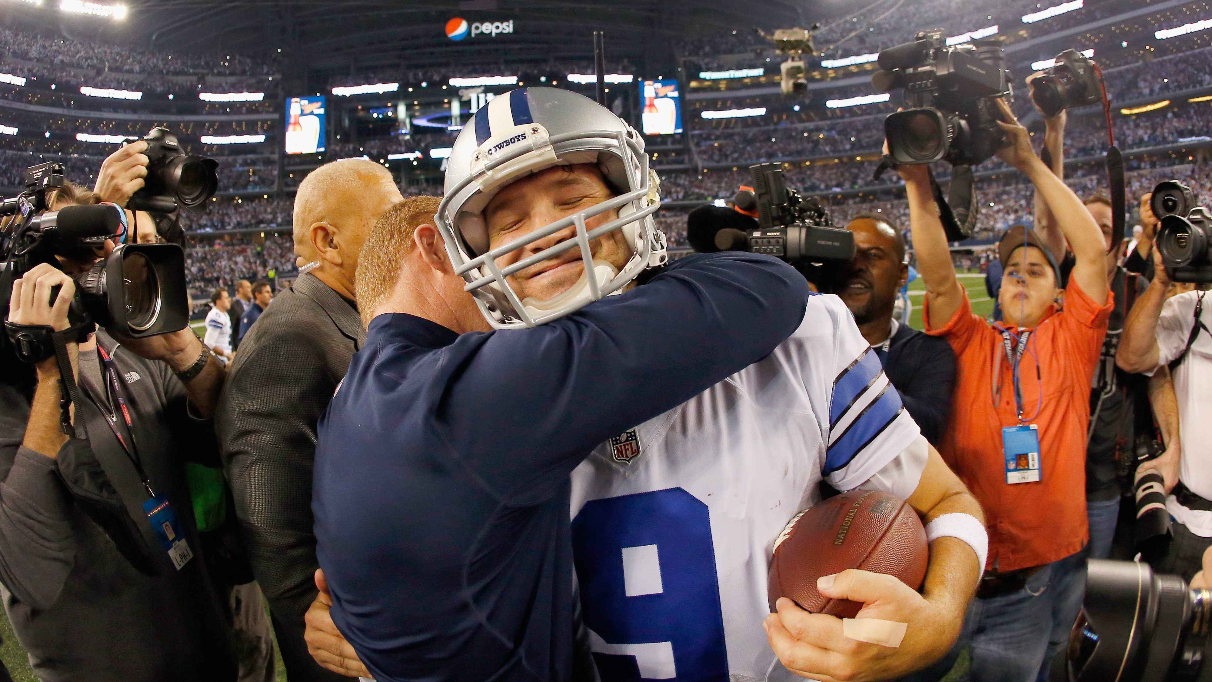 ARLINGTON, TX - JANUARY 04: Quarterback Tony Romo #9 of the Dallas Cowboys celebrates with head coach Jason Garrett of the Dallas Cowboys after the Cowboys beat the Detroit Lions 24-20 during a NFC Wild Card Playoff game at AT&T Stadium on January 4, 2015 in Arlington, Texas. (Photo by Tom Pennington/Getty Images)